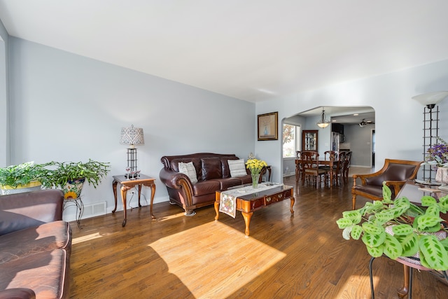 living room with ceiling fan and dark wood-type flooring