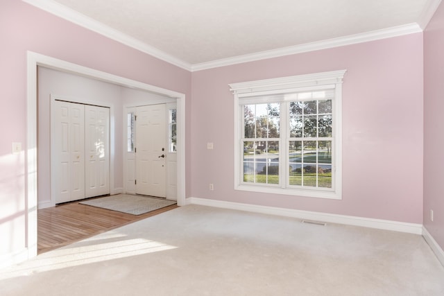 carpeted foyer with crown molding