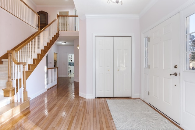 foyer entrance with light wood-type flooring and crown molding