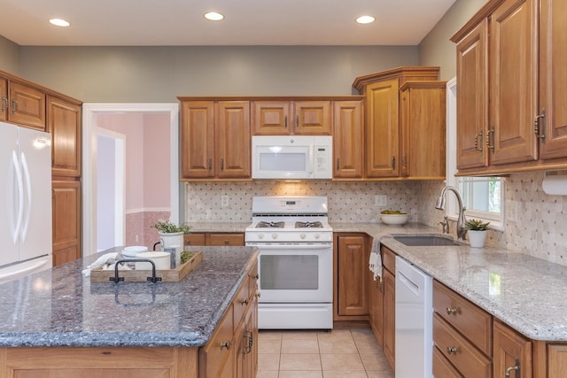 kitchen featuring light tile patterned flooring, sink, white appliances, and stone countertops