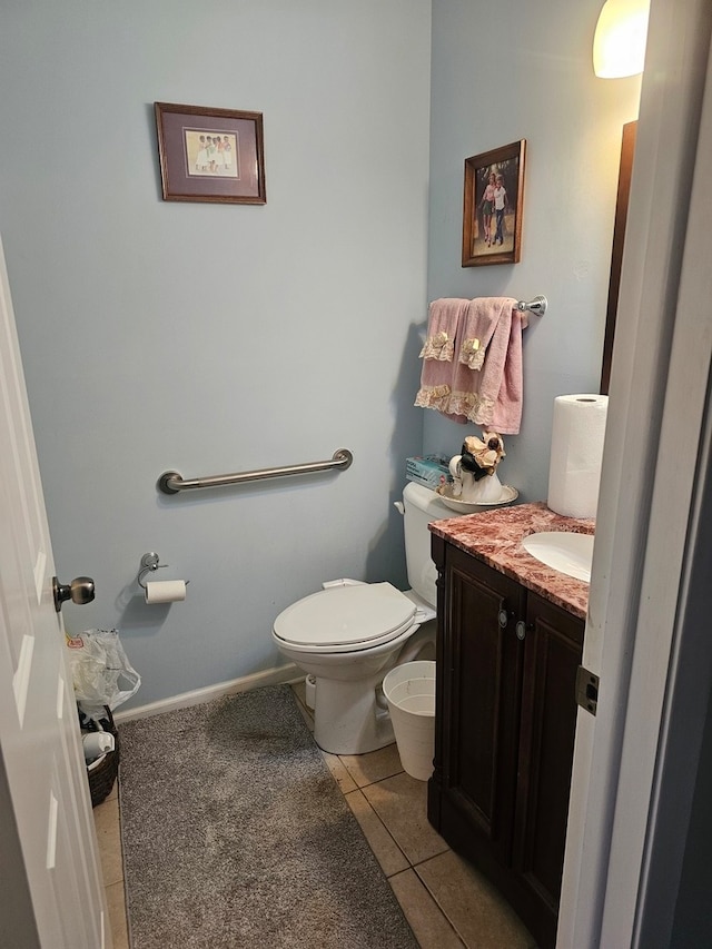 bathroom with toilet, vanity, and tile patterned flooring