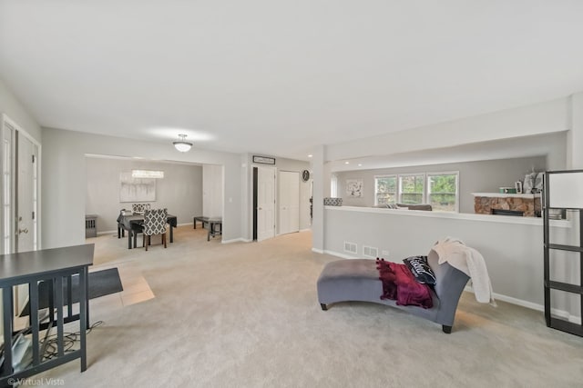 sitting room featuring a fireplace and light carpet