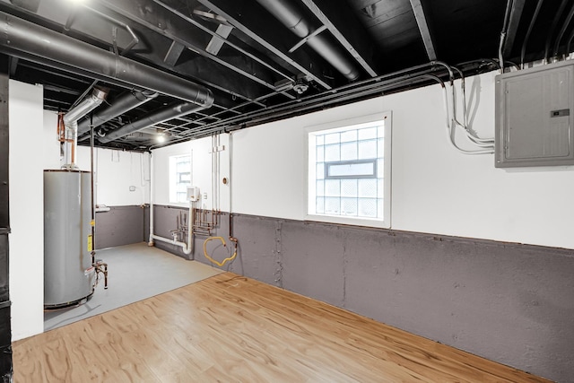 below grade area featuring electric panel, water heater, and a healthy amount of sunlight