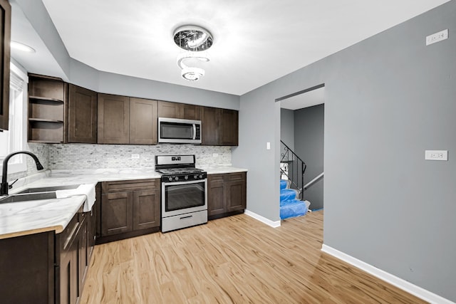 kitchen featuring dark brown cabinets, backsplash, open shelves, and appliances with stainless steel finishes