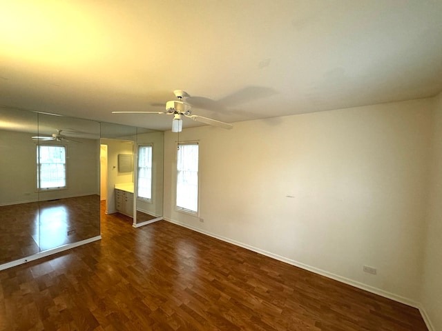 spare room with plenty of natural light and dark hardwood / wood-style flooring