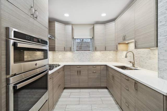 kitchen featuring backsplash, light tile patterned floors, sink, and appliances with stainless steel finishes