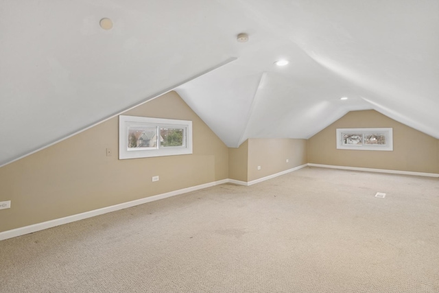 additional living space with light carpet and lofted ceiling