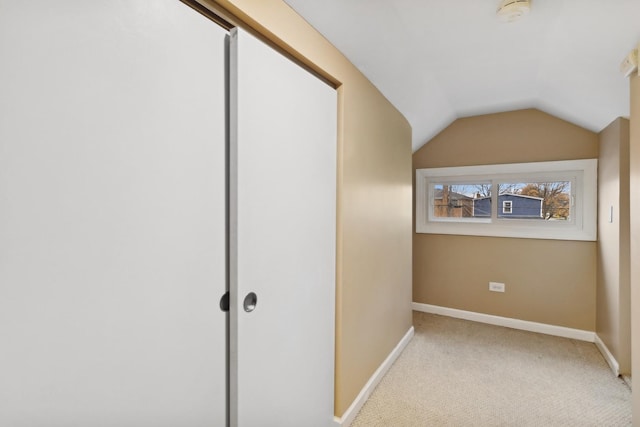 interior space featuring light carpet and vaulted ceiling