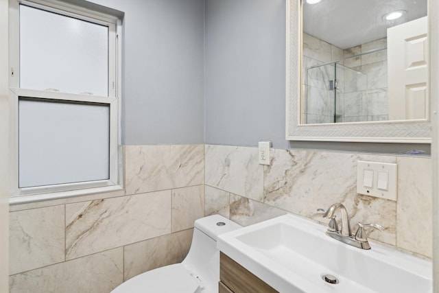 bathroom with tiled shower, vanity, and toilet