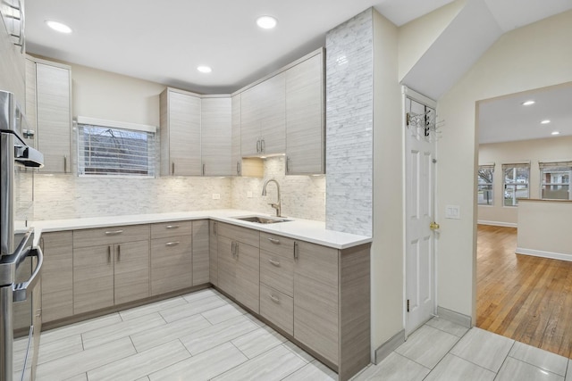 kitchen featuring light wood-type flooring, double oven, a wealth of natural light, and sink