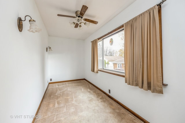 empty room featuring ceiling fan and light colored carpet