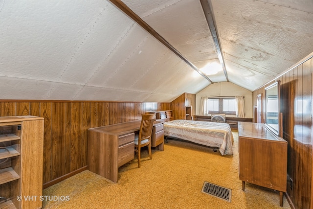 bedroom with light carpet, a textured ceiling, vaulted ceiling, and wooden walls