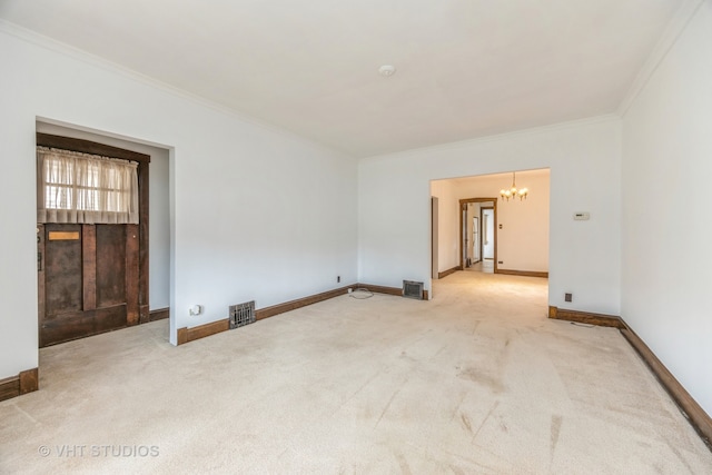 carpeted spare room featuring an inviting chandelier and crown molding