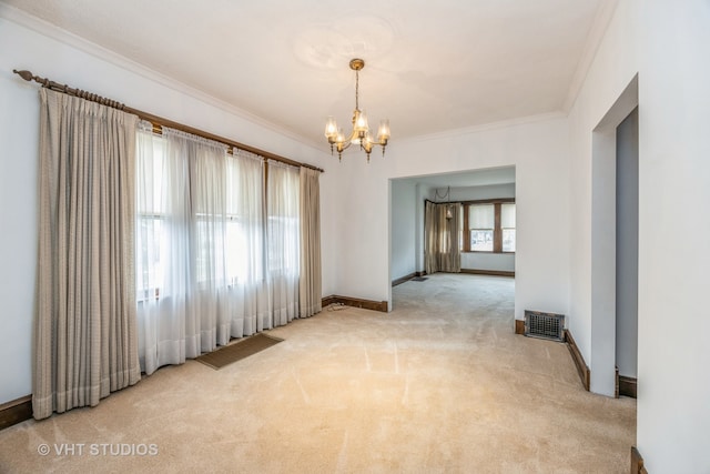 carpeted empty room featuring an inviting chandelier and crown molding