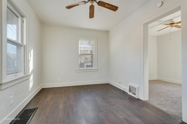 empty room with ceiling fan and dark wood-type flooring