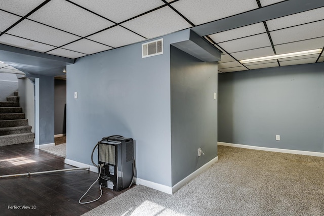 basement featuring a paneled ceiling and hardwood / wood-style flooring