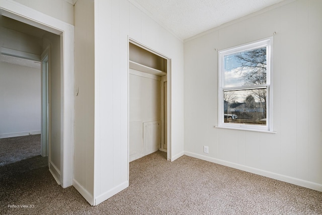 unfurnished bedroom featuring carpet floors, a textured ceiling, and a closet