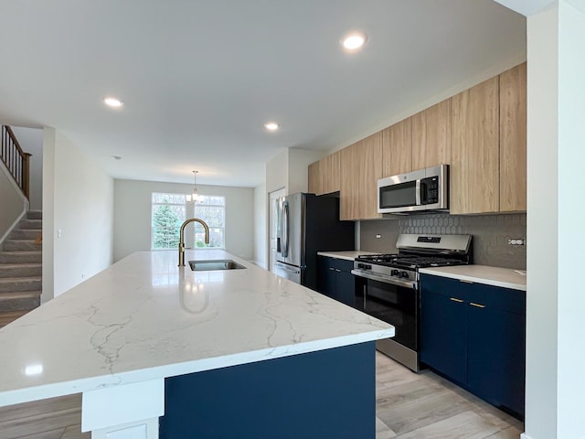235 Regency Ct Unit B, Wauconda, IL 60084 - kitchen featuring appliances with stainless steel finishes, a sink, a center island with sink, modern cabinets, and decorative backsplash