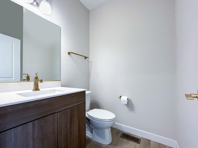 235 Regency Ct Unit B, Wauconda, IL 60084 - bathroom featuring toilet, vanity, baseboards, and wood finished floors