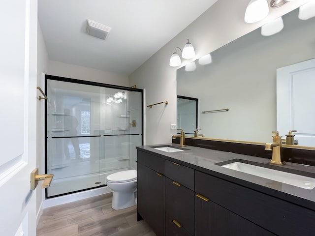 235 Regency Ct Unit B, Wauconda, IL 60084 - full bath featuring toilet, a stall shower, wood finished floors, and double vanity