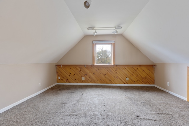 bonus room featuring wooden walls, lofted ceiling, and carpet