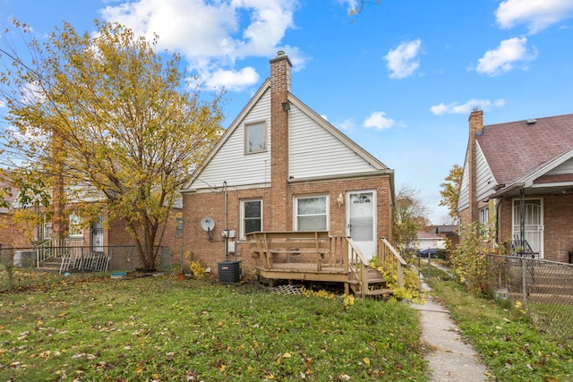 back of property with a wooden deck and a yard