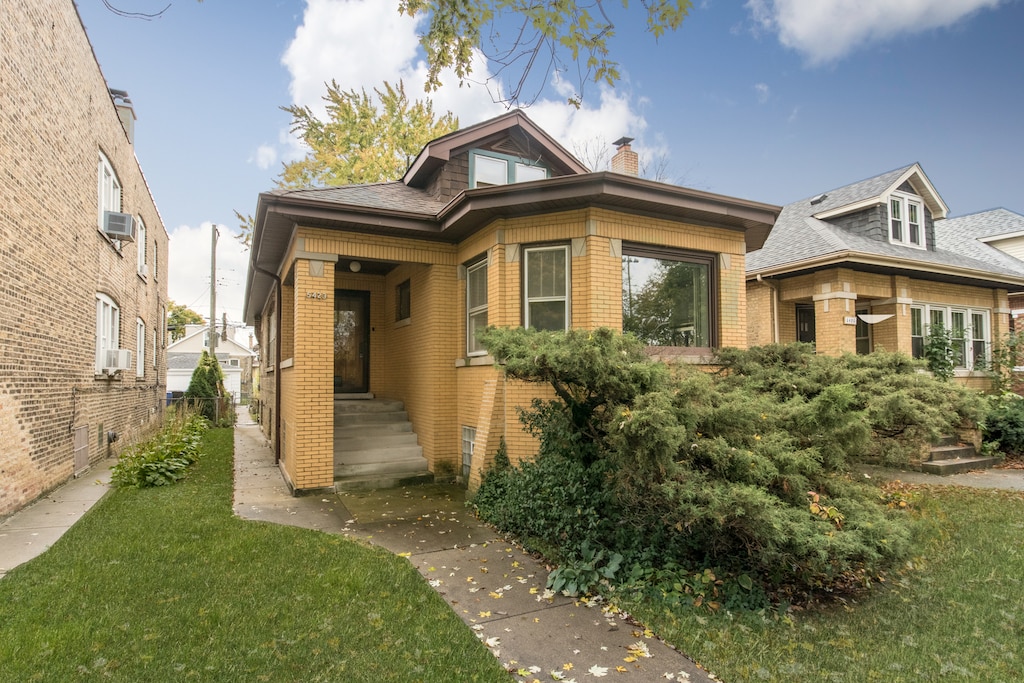 view of front of home with a front lawn and cooling unit