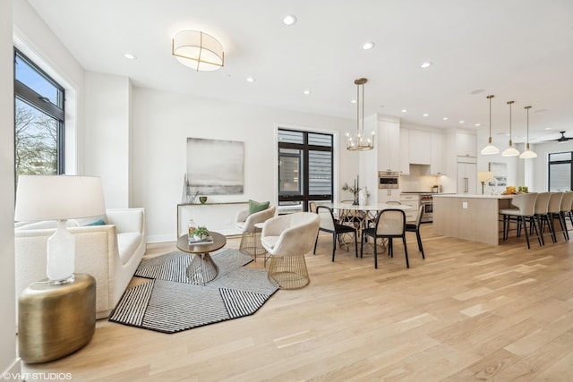 dining space featuring an inviting chandelier and light hardwood / wood-style flooring