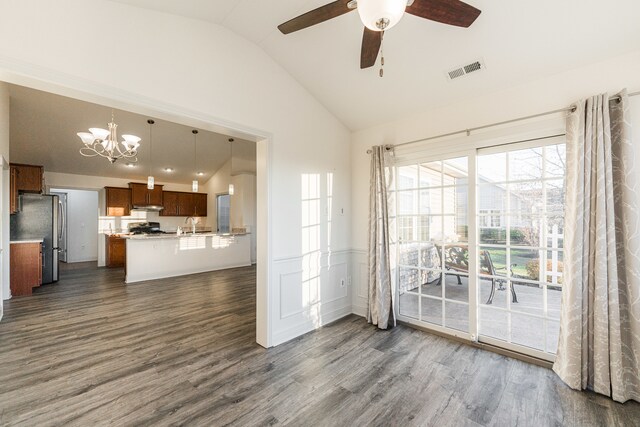 interior space with dark hardwood / wood-style flooring, lofted ceiling, and ceiling fan with notable chandelier