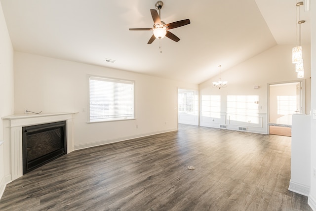 unfurnished living room featuring dark hardwood / wood-style flooring, high vaulted ceiling, and ceiling fan with notable chandelier