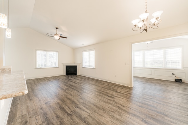 unfurnished living room with lofted ceiling, dark hardwood / wood-style floors, and ceiling fan with notable chandelier