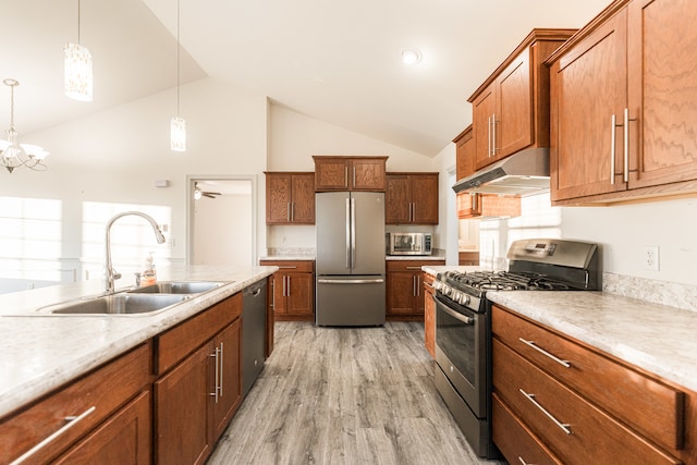 kitchen with ceiling fan with notable chandelier, sink, light wood-type flooring, appliances with stainless steel finishes, and decorative light fixtures