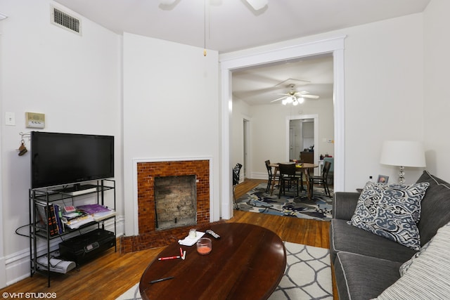 living room featuring wood-type flooring and ceiling fan