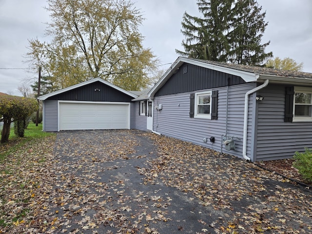 view of side of home featuring an outbuilding and a garage