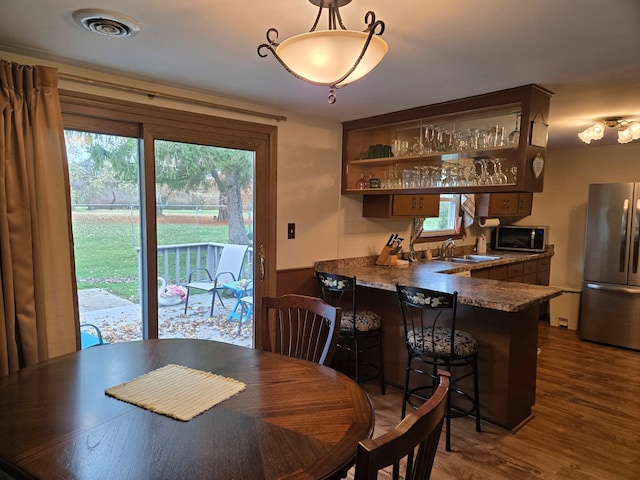 dining space featuring dark hardwood / wood-style flooring and indoor wet bar