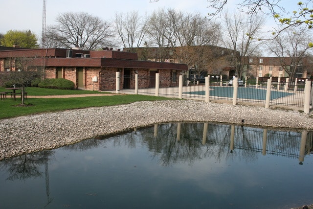 back of house featuring a water view and a community pool