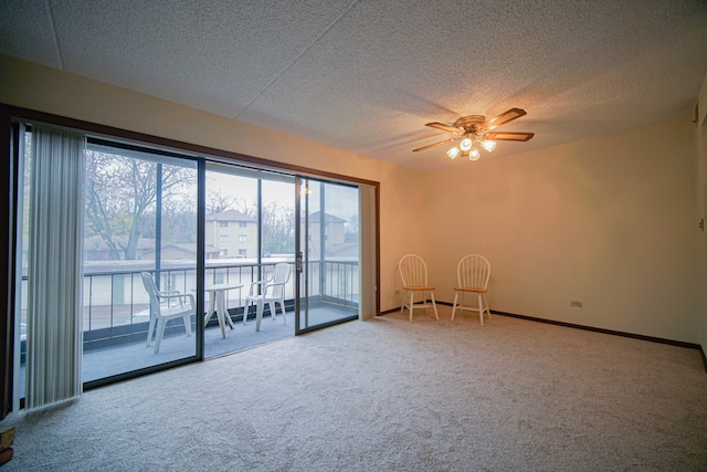 carpeted empty room featuring a textured ceiling and ceiling fan