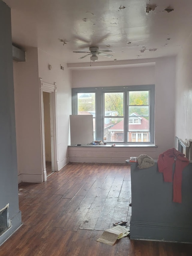 unfurnished living room featuring dark wood-type flooring, a healthy amount of sunlight, and ceiling fan