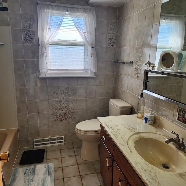 bathroom featuring toilet, vanity, tile walls, and tile patterned flooring