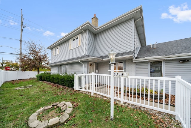 rear view of property featuring a yard and a deck