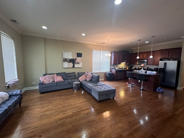 living room with ornamental molding, dark hardwood / wood-style flooring, and a chandelier