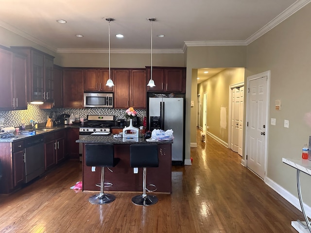 kitchen with stainless steel appliances, a kitchen breakfast bar, decorative light fixtures, a kitchen island, and dark hardwood / wood-style flooring