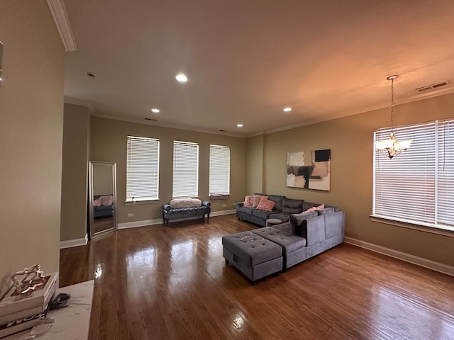 living room featuring hardwood / wood-style floors, an inviting chandelier, and ornamental molding