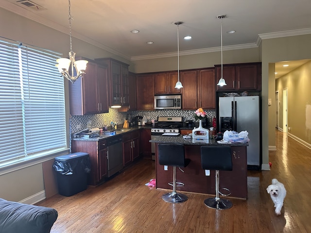 kitchen with stainless steel appliances, a breakfast bar area, pendant lighting, and a kitchen island