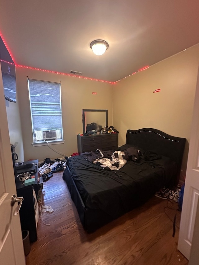 bedroom with wood-type flooring and cooling unit