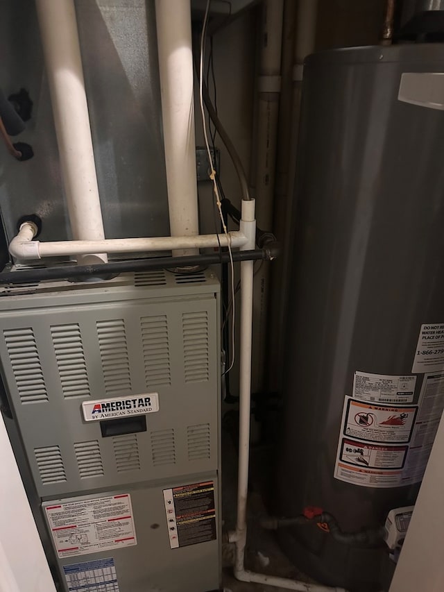 utility room featuring gas water heater and heating unit