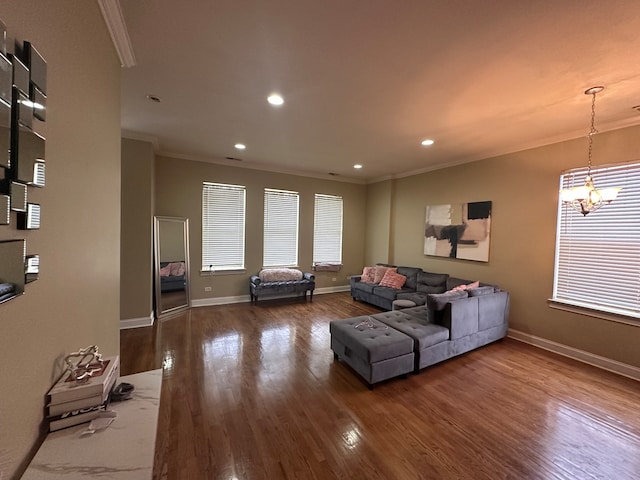 living room featuring ornamental molding, hardwood / wood-style flooring, and an inviting chandelier