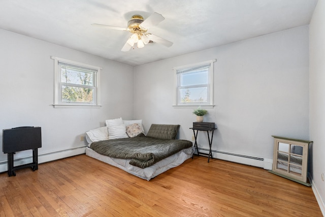 sitting room featuring hardwood / wood-style flooring, ceiling fan, and a baseboard heating unit