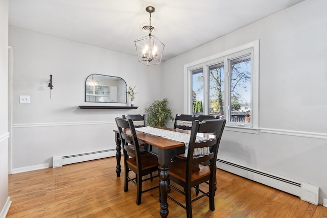 dining room featuring light hardwood / wood-style floors, a chandelier, and a baseboard heating unit