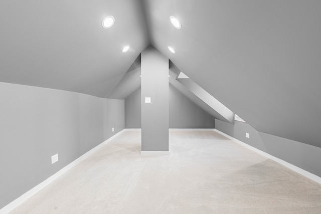 bonus room with light colored carpet and lofted ceiling